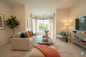 Buffalo apartment for rent - A living room with a white couch, a coffee table, and a large window.
