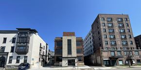 Buffalo apartment for rent - A row of buildings with a white building on the left and a brown building on the right.
