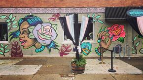 Buffalo apartment for rent - A mural of a woman's face with a rose is painted on a wall.