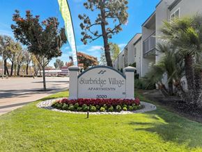 Fullerton apartment for rent - A sign for Sturbridge Village Apartments is in front of a building.