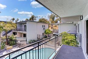 Fullerton apartment for rent - A second floor balcony with a pool view and trees.