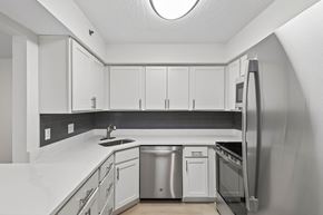 Bloomington apartment for rent - A kitchen with white cabinets and a black backsplash.