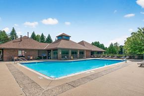 Bloomington apartment for rent - A large outdoor swimming pool with a building in the background.