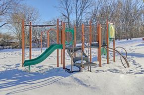 Minnetonka townhouse for rent - A playground with a green slide and orange structure in the snow.