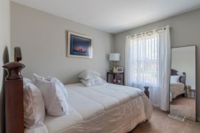 Manassas apartment for rent - A bedroom with a large bed and a painting on the wall.