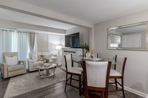 Manassas apartment for rent - A living room with a white sofa, a glass coffee table, and a television.