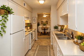 Mission townhouse for rent - A white kitchen with a refrigerator, sink, and a dining table with chairs.