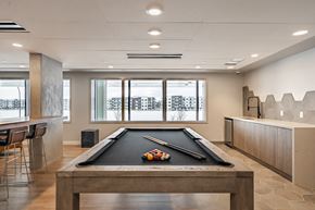 Seton apartment for rent - A pool table with a black cloth and white balls is in the center of the room.