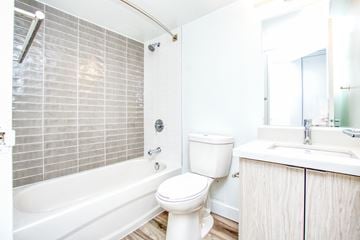 Toronto apartment for rent - A white toilet sits next to a bathtub in a bathroom.