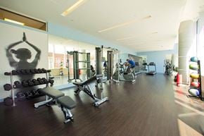 Toronto apartment for rent - A gym with a variety of equipment including weights and exercise machines.