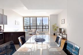 Toronto apartment for rent - A modern dining room with a glass table and chairs.