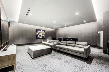 Newmarket apartment for rent - A modern living room with a grey sofa and a patterned carpet.