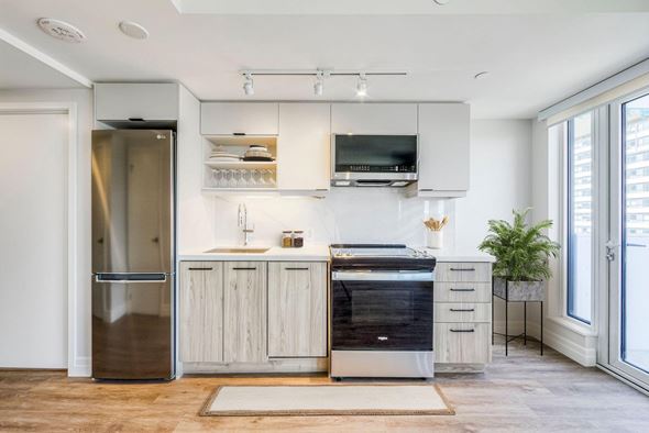 Toronto apartment for rent - A modern kitchen with a stainless steel refrigerator and wooden cabinets.