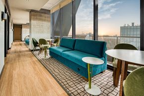 Toronto apartment for rent - A long blue couch sits in a room with a table and chairs.