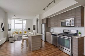 Calgary apartment for rent - A modern kitchen with a wooden floor and stainless steel appliances.
