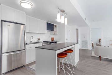 Winnipeg apartment for rent - A modern kitchen with a stainless steel refrigerator and a central island with bar stools.
