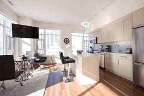 Calgary apartment for rent - A modern kitchen with a dining table and chairs.