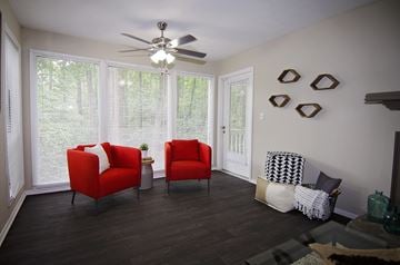 Duluth apartment for rent - A living room with two red chairs and a ceiling fan.