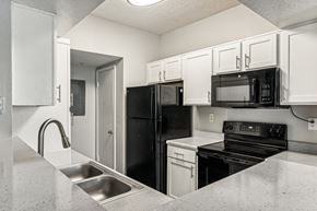 Charlotte apartment for rent - A kitchen with black appliances and white cabinets.