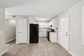 Clarkston apartment for rent - A kitchen with a black refrigerator and white cabinets.