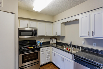 Nashville apartment for rent - A kitchen with white cabinets and a black stove top.