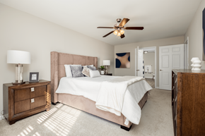 Charlotte apartment for rent - A bedroom with a large bed and a ceiling fan.