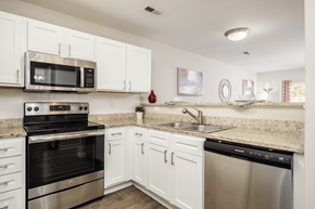 Charlotte apartment for rent - A kitchen with white cabinets and stainless steel appliances.