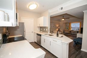 Atlanta apartment for rent - A kitchen with white cabinets and a black counter top.