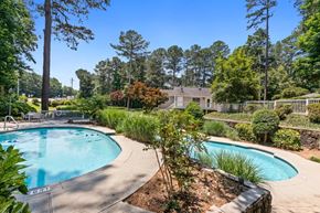 Duluth apartment for rent - A swimming pool surrounded by a garden and trees.