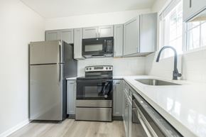 Riverdale townhouse for rent - A modern kitchen with stainless steel appliances and a white countertop.