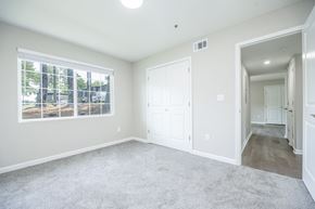 Riverdale townhouse for rent - A spacious room with a large window and carpeted floor.