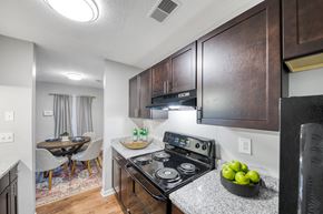 Stone Mountain apartment for rent - A kitchen with a stove top oven and a bowl of green apples on the counter.
