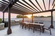 Atlanta apartment for rent - a patio with a wooden table and chairs and a grill with a sunset in the background