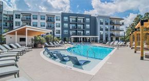 Duluth apartment for rent - an outdoor swimming pool with lounge chairs and an apartment building