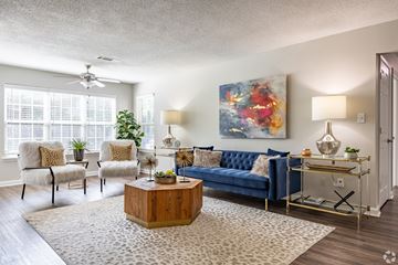 Morrow apartment for rent - A living room with a blue couch, a wooden coffee table, and a painting on the wall.