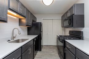 Duluth apartment for rent - A kitchen with black cabinets and appliances.