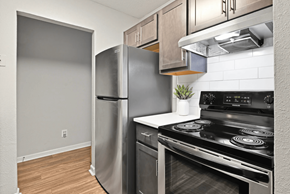 Austell apartment for rent - A kitchen with a black stove top oven and a silver refrigerator.