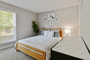 Austell apartment for rent - A bedroom with a bed, nightstand, and pictures on the wall.