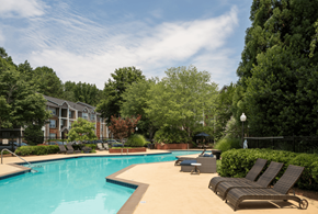 Peachtree Corners apartment for rent - A swimming pool surrounded by trees and chairs.