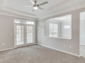 Peachtree Corners apartment for rent - A spacious room with a ceiling fan and sliding glass doors.