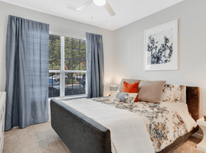 Peachtree Corners apartment for rent - A bedroom with a large bed and a ceiling fan.