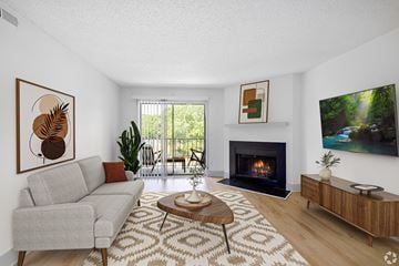 Charlotte apartment for rent - A living room with a grey couch, a coffee table, a fireplace, and a painting on the wall.