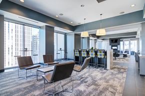 Atlanta apartment for rent - a lounge area with chairs and a bar in a room with large windows