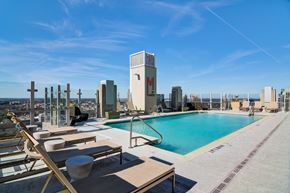 Atlanta apartment for rent - a swimming pool on the rooftop of a building with a city in the background