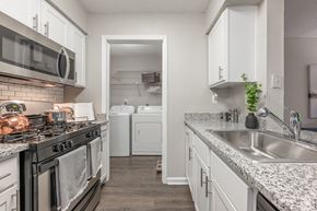 Peachtree Corners apartment for rent - A kitchen with a black stove top oven and white cabinets.