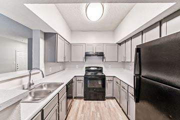 Charlotte apartment for rent - A kitchen with a black refrigerator and a black oven.