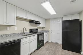 Clarkston apartment for rent - A kitchen with black appliances and white cabinets.