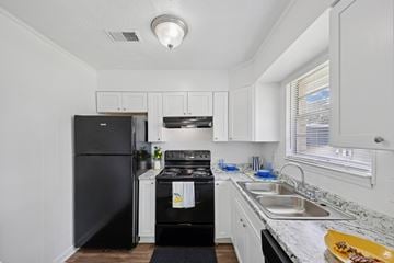 Riverdale townhouse for rent - A black fridge and oven in a white kitchen.