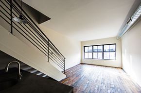 Philadelphia apartment for rent - an empty living room with a staircase and a window