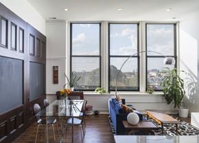 Philadelphia apartment for rent - A modern living room with a glass table and a view of the city.
